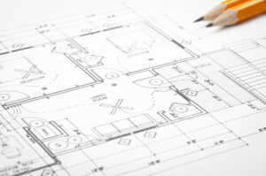 Construction planning drawings on the table and two yellow pencils